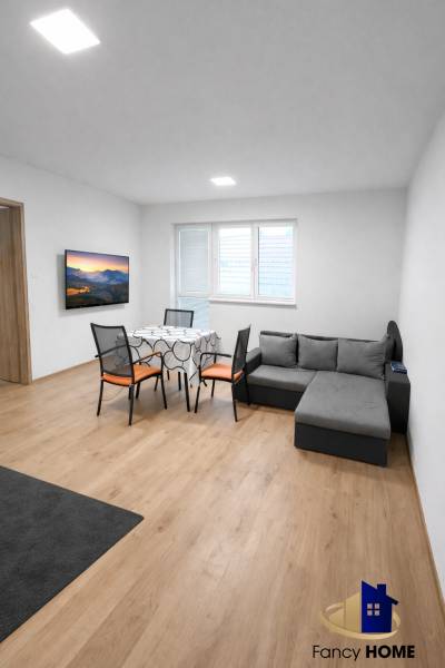 Living room with a sofa and a table in a two-room apartment, floor with wooden decor.