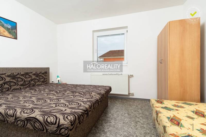 A room in a hotel or guesthouse with a unique bed pattern and a wall painting.