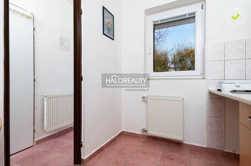 A corridor with a radiator, ceramic tiles, and a window with a view, hotels and guesthouses.
