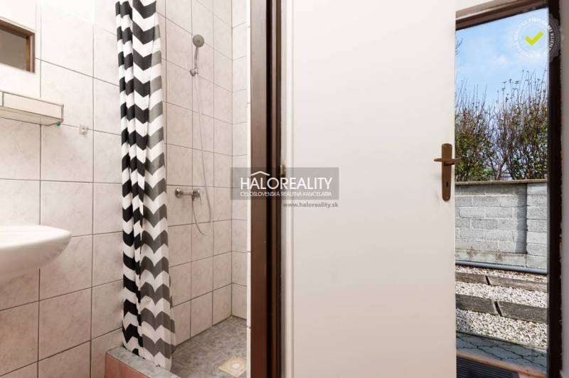 A bathroom with a shower and a patterned curtain in hotels and guesthouses.