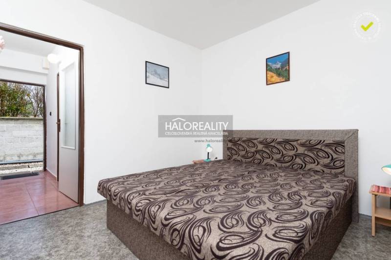 A bedroom with a double bed, white walls, and paintings in hotels and guesthouses.