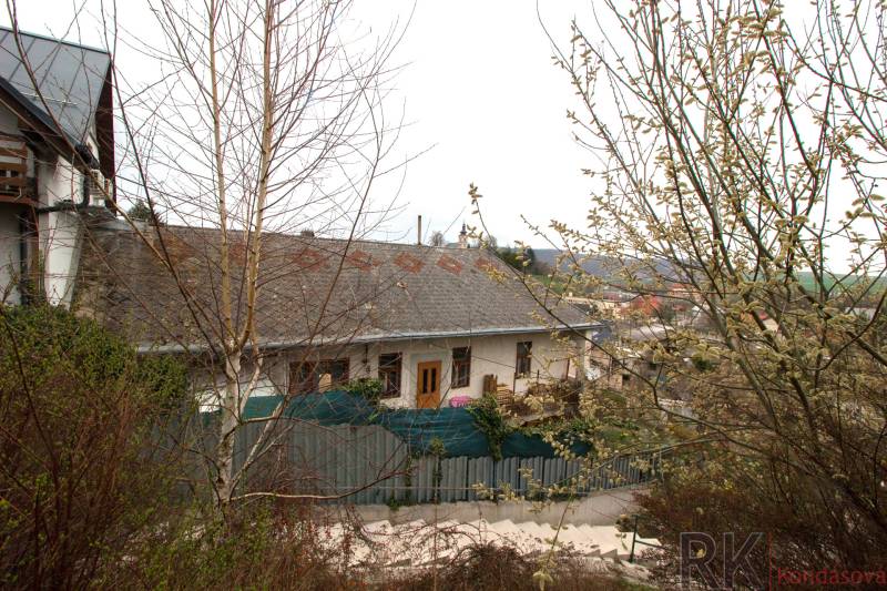 A soaked family house in Kostoľany nad Hornádom surrounded by greenery and shrubs.