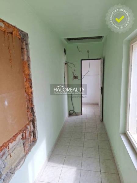 A narrow interior with light green walls and a tiled floor.