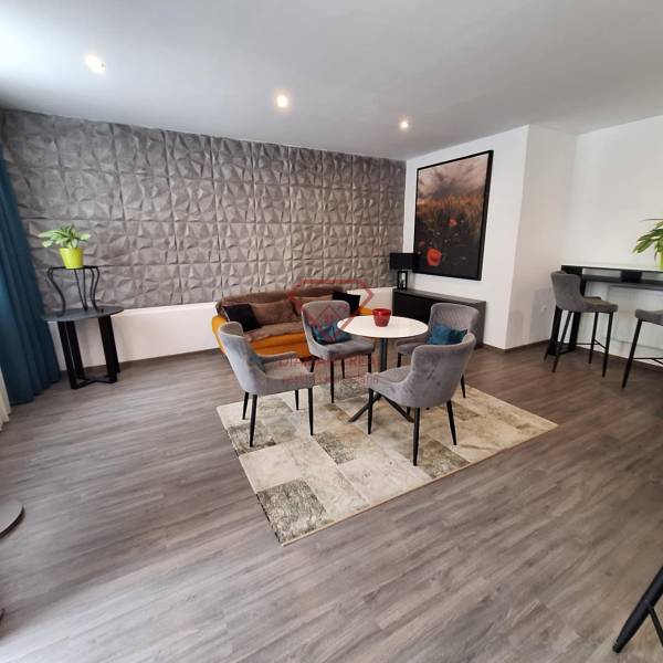 Living room with armchairs and a sofa in a family house, decorative wall and bar corner.