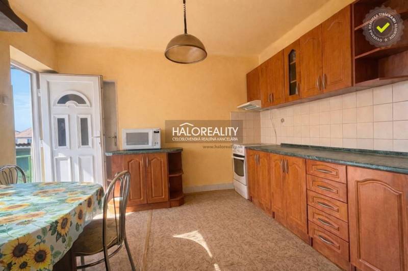A family house kitchen with wooden decor and a sunny wall decoration.