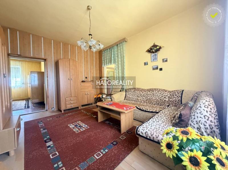 Living room in a family house with a wooden decor floor and flowers.