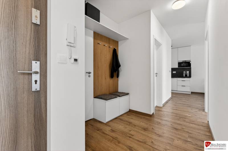 Entrance hallway in a 2-room apartment with wood-patterned flooring and built-in storage space.