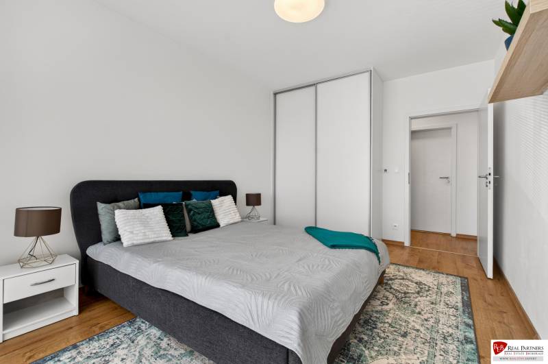 Bedroom in a 2-room apartment with a bed, nightstand, and wardrobe.