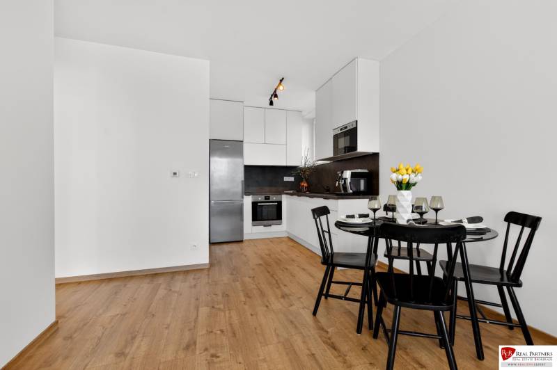 A kitchen with a dining table in a 2-room apartment, floor with a wooden decor.