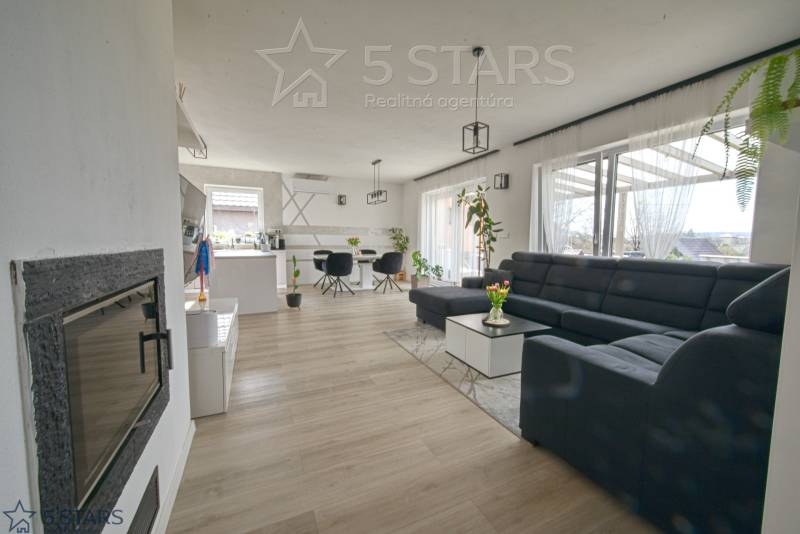 Living room in a family house with a large sofa and a wooden decor floor.