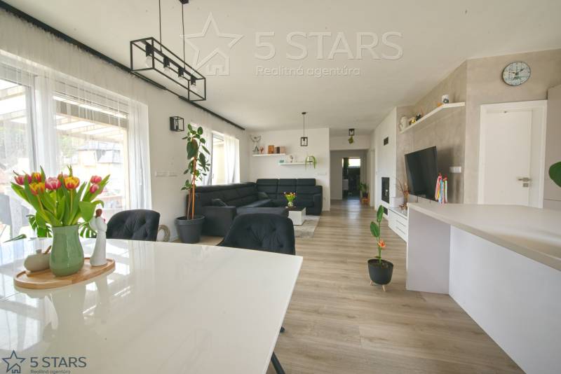 Interior of a family house with a wooden decor floor, dining table, and sofa.