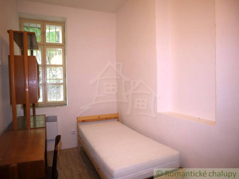 Simple bedroom with a single bed and wooden furniture in a family house.