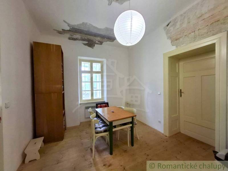 A dining room in a family house with a simple table and a wooden decor floor.