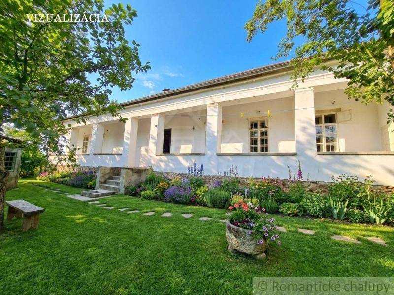 A family house in Dobroč with a garden and flower beds, lined with trees and a bench.