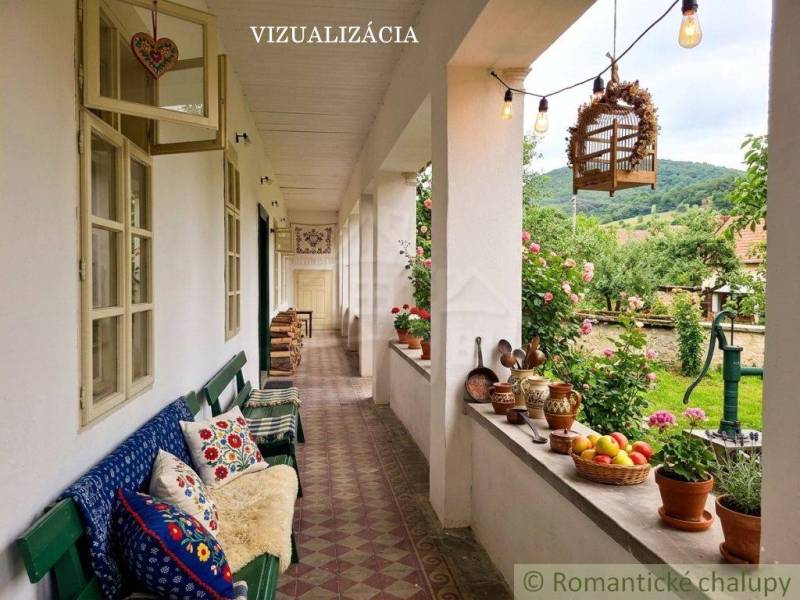 The veranda of a family house in Dobroč with decorations, cushions, and a view of the garden.