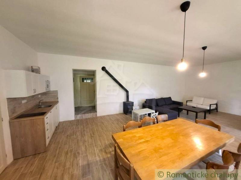 Living room in a family house with wood-patterned flooring, a fireplace, and sofas.