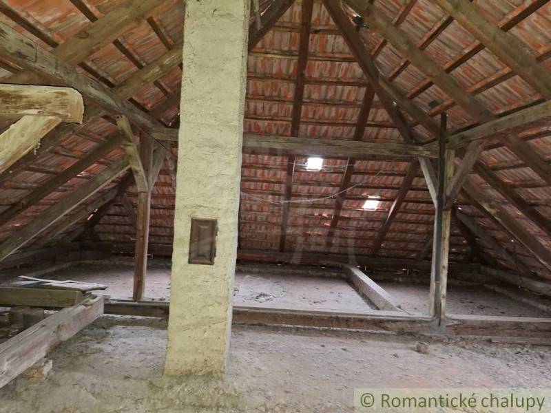Attic in a family house with wooden beams and a brick roof.