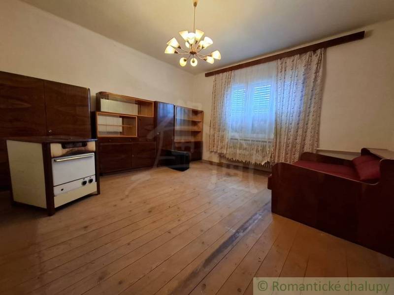 Living room in a family house with wooden decor, curtains, and a sofa.