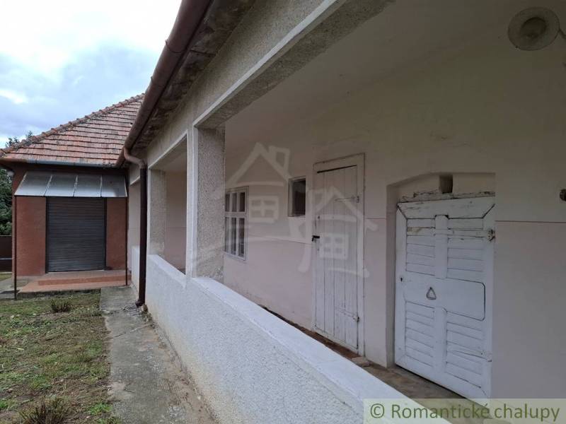 A family house in Mužla with a white facade and a sloped roof made of red tiles.
