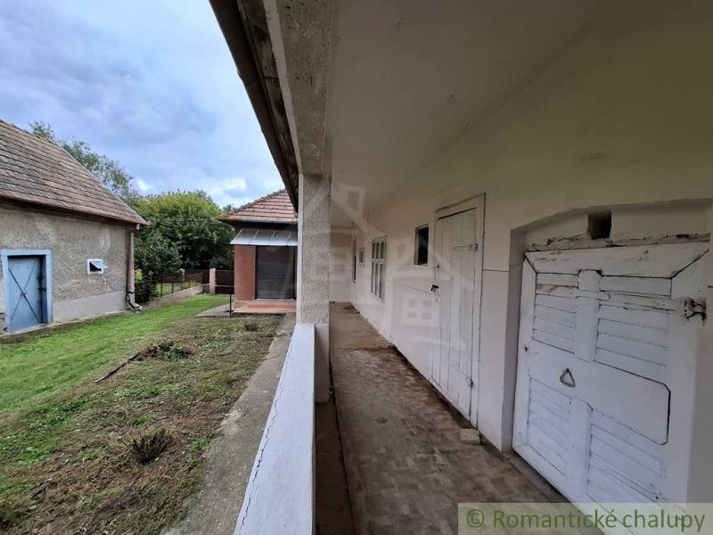 A family house in Mužla with a veranda and garden, country style and simple architecture.
