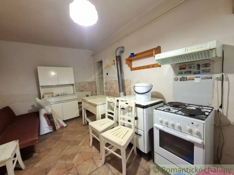A kitchen in a family house with a gas stove and wooden furniture.