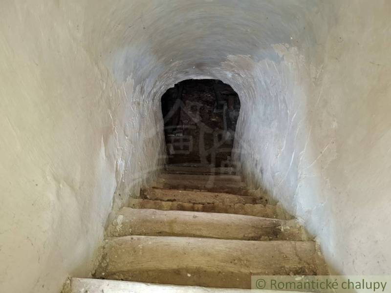 Stone stairs leading to the basement in a family house, walls with thick plaster.