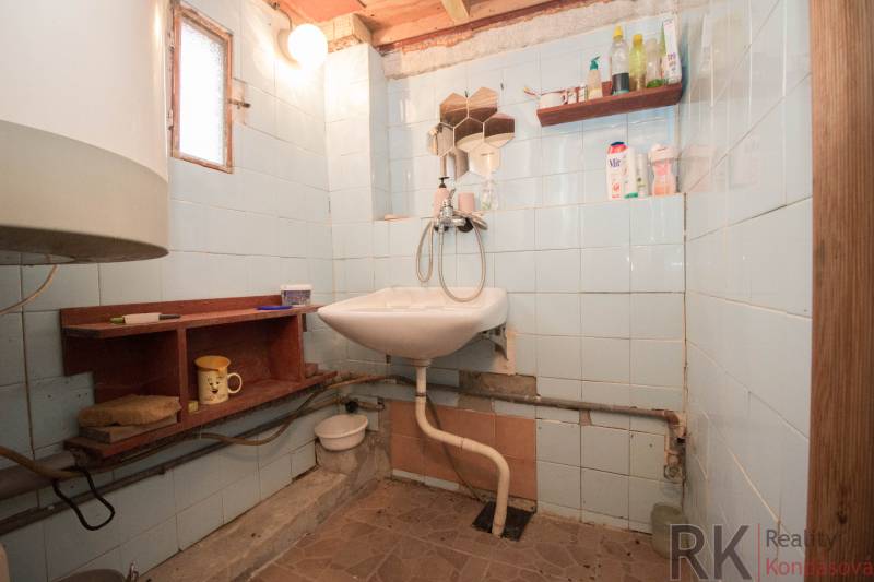Bathroom with a sink, shelves, and light, suitable for recreational properties.
