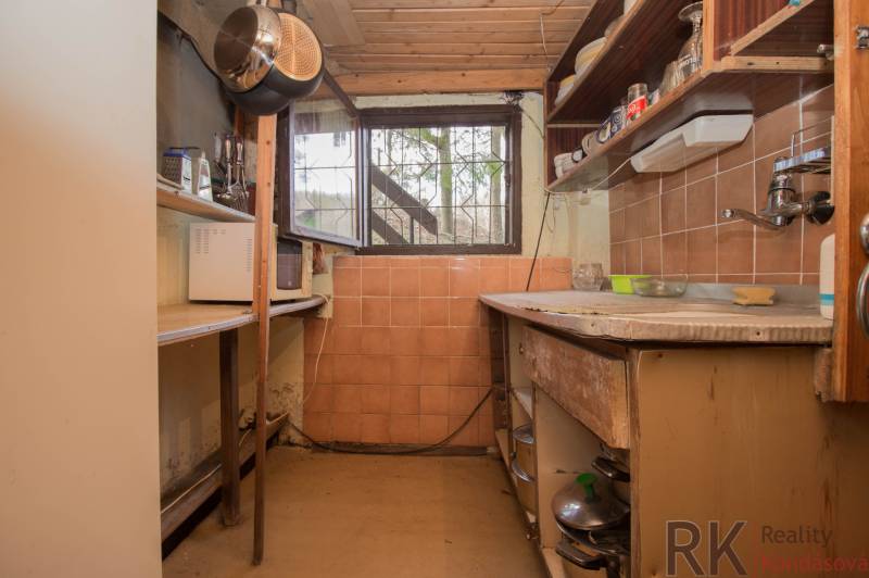 A small kitchen with shelves and old furniture on recreational grounds.