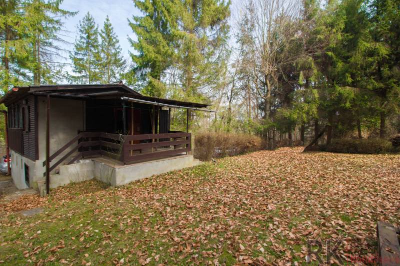 A cottage in nature on Recreational lands in Holčíkovce, surrounded by coniferous trees.