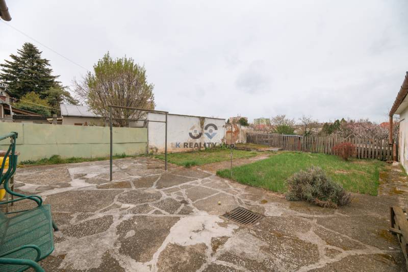 A garden at a family house on Zelenečská Street in Trnava with a lawn and paving.