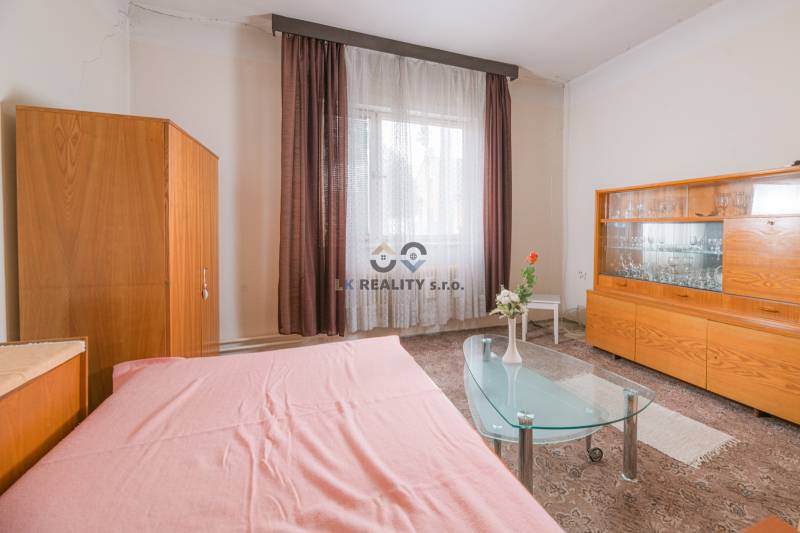 Interior of a family house with a glass table, furniture, and curtains.