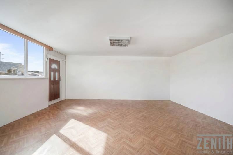 Spacious commercial premises with a large window and a wooden decor floor.