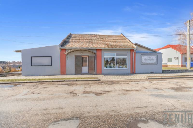 Commercial premises in the town of Okoč with display windows and a sloped roof.