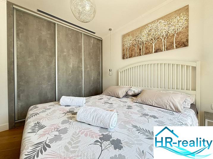 A bright bedroom in a villa with a large bed and a painting above the headboard.