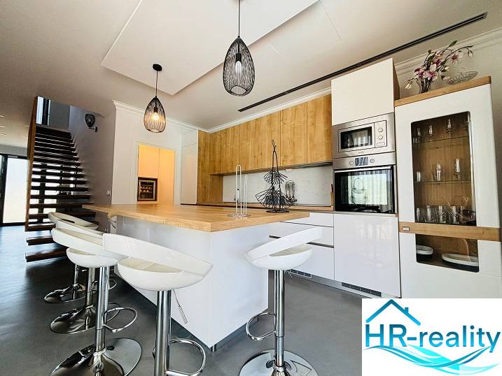 A modern kitchen with an island and bar stools in the villa.