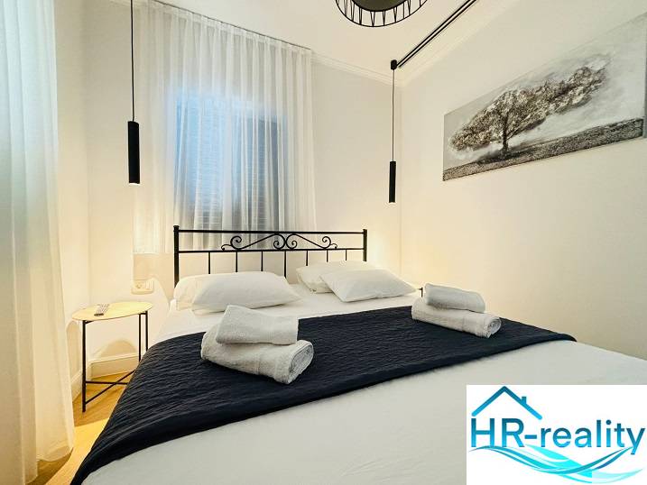 Cozy bedroom in a villa with a black metal bed frame and hanging lamps.