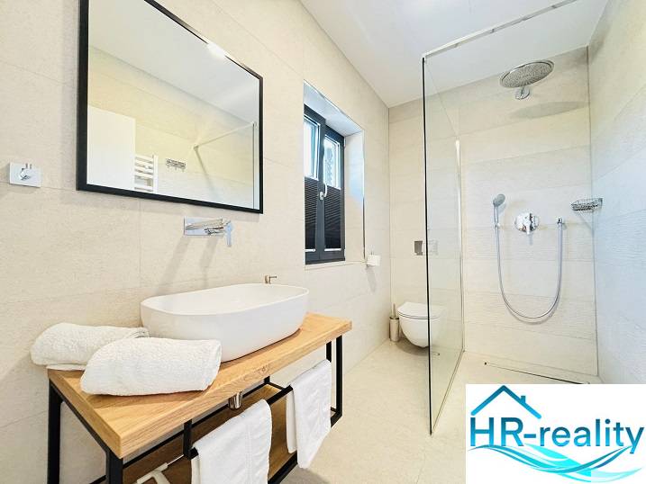 A bathroom in a villa with modern amenities, a shower cabin, and a countertop sink.