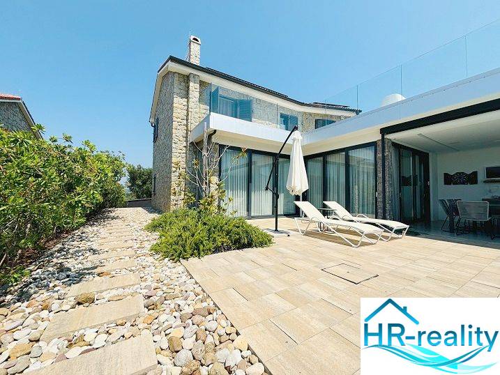 Villa in Jakišnica with a terrace, stone pathway, and loungers for relaxation.