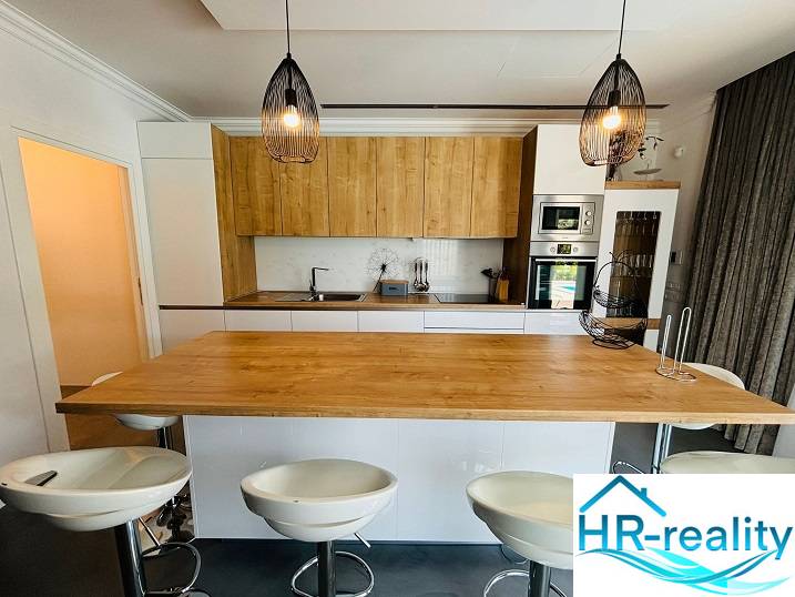 A kitchen in a villa with wooden decor and elegant lighting.