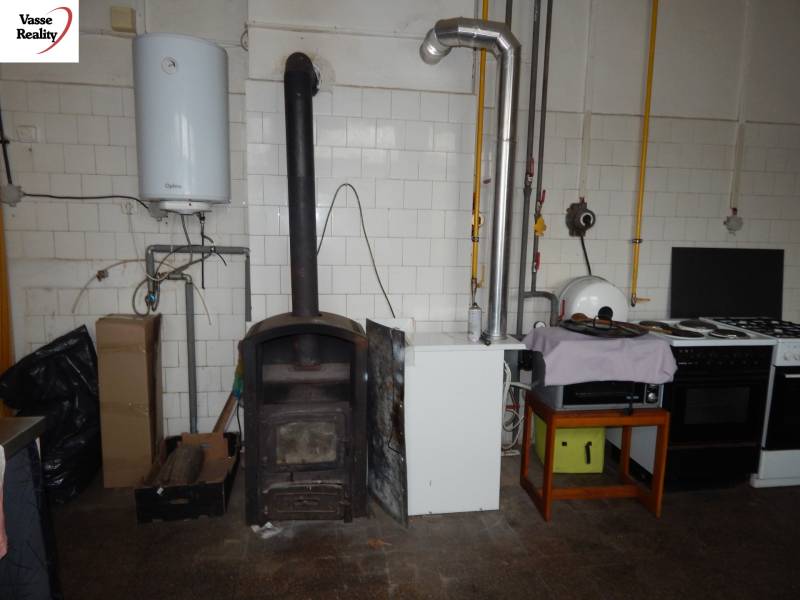 Gastro premises with a tiled stove and appliances, floor with wooden decor.