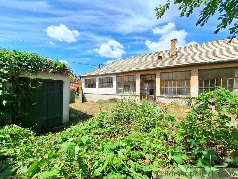 The back side of the cottage in Kamenný Most with a garden and blue sky.