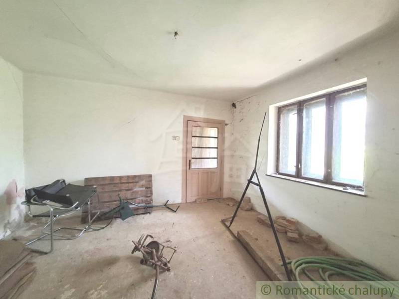 Interior of the cabin: a room with simple furnishings and wooden doors.