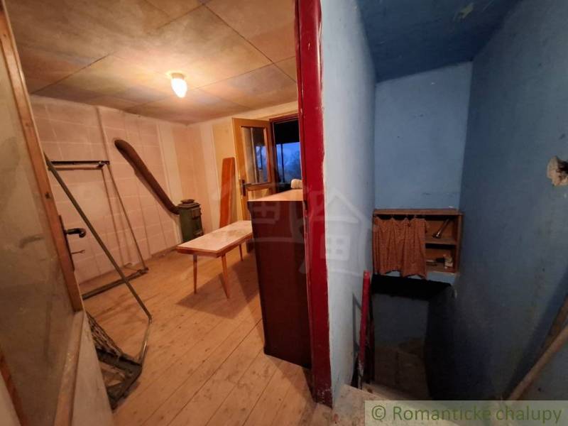 Interior of a cabin with a wood-patterned floor, hallway, and table.