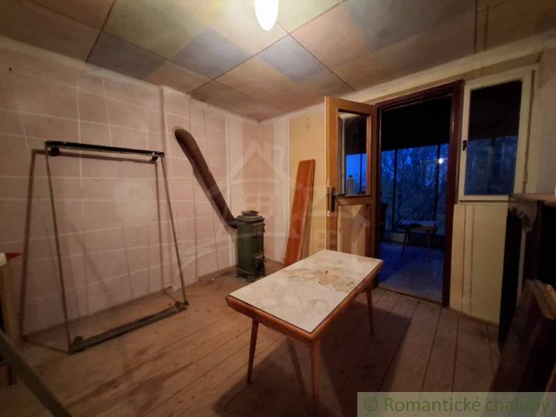 The interior of a cabin with a wooden decor floor and old furniture.