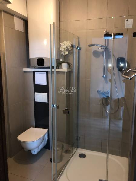 Bathroom in a 2-room apartment with a shower and toilet, elegant decoration.