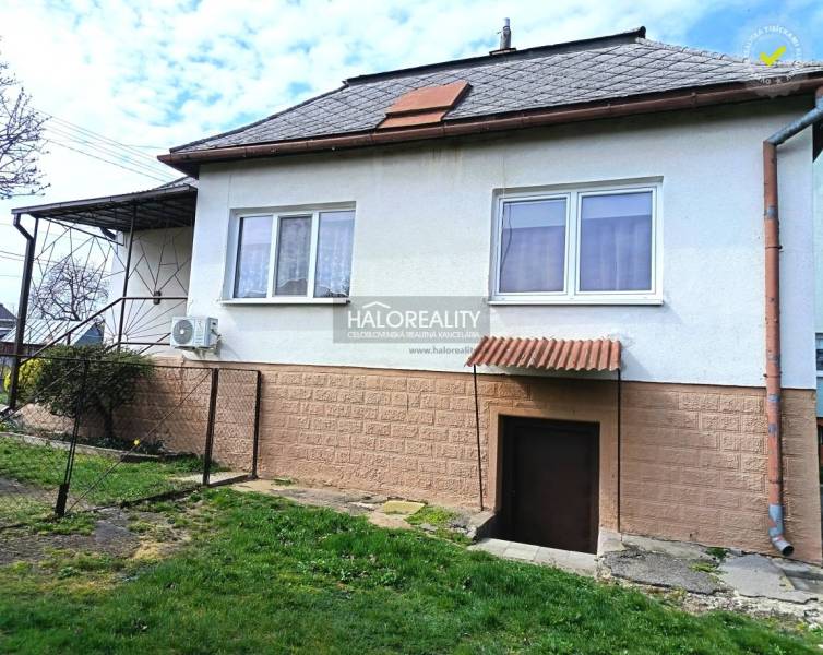 A family house in Hráň with a grassy yard, windows, and entrance doors.