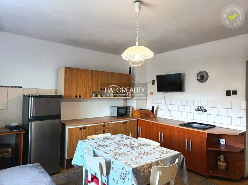 A kitchen in a family house with wooden kitchen furniture and a dining table.
