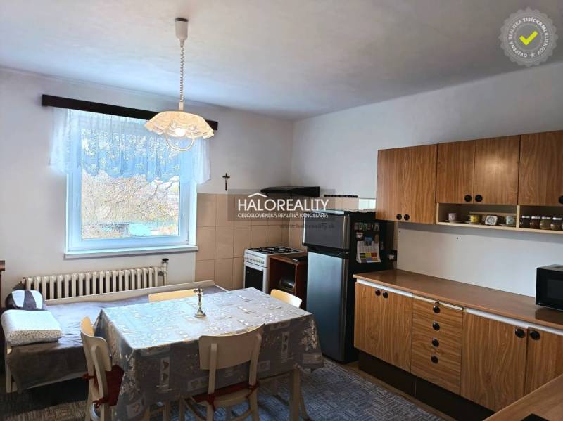 A kitchen in a family house with a dining table and wooden cabinets.