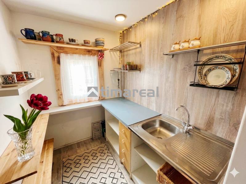 A kitchen in a family house with shelves and a wooden decor floor.