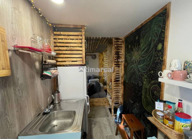 A kitchen corner with wooden decorations and shelves, a floor with a wooden decor.